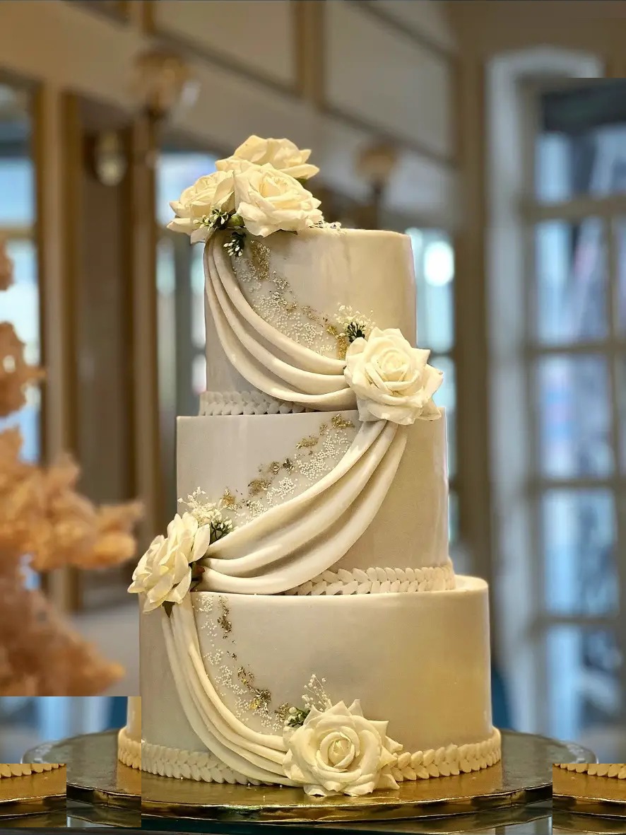 Wedding cake à trois étages orné de roses blanches